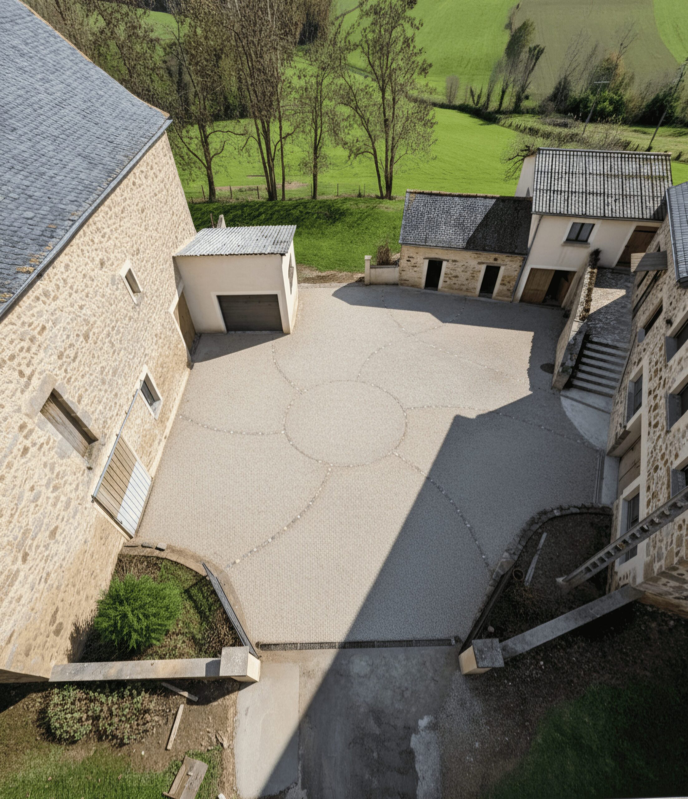 Cour intérieure en pierre aménagée par mobilier-design-pierre-aveyron dans une maison de campagne en Aveyron