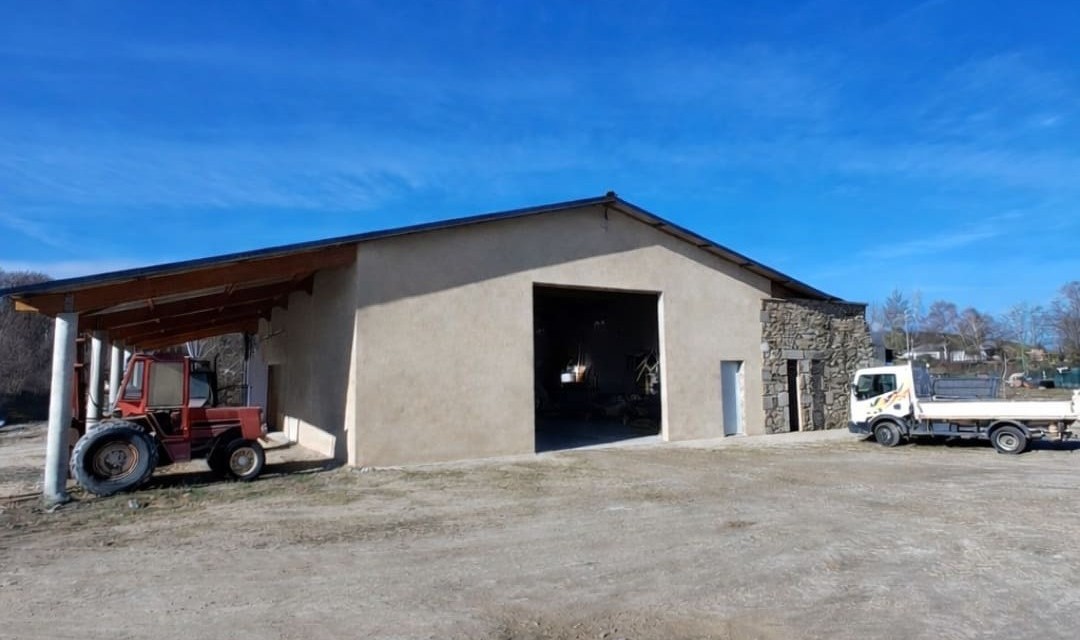 Hangar agricole avec tracteur et camion, décor rural hivernal pour mobilier-design-pierre-aveyron en Aveyron