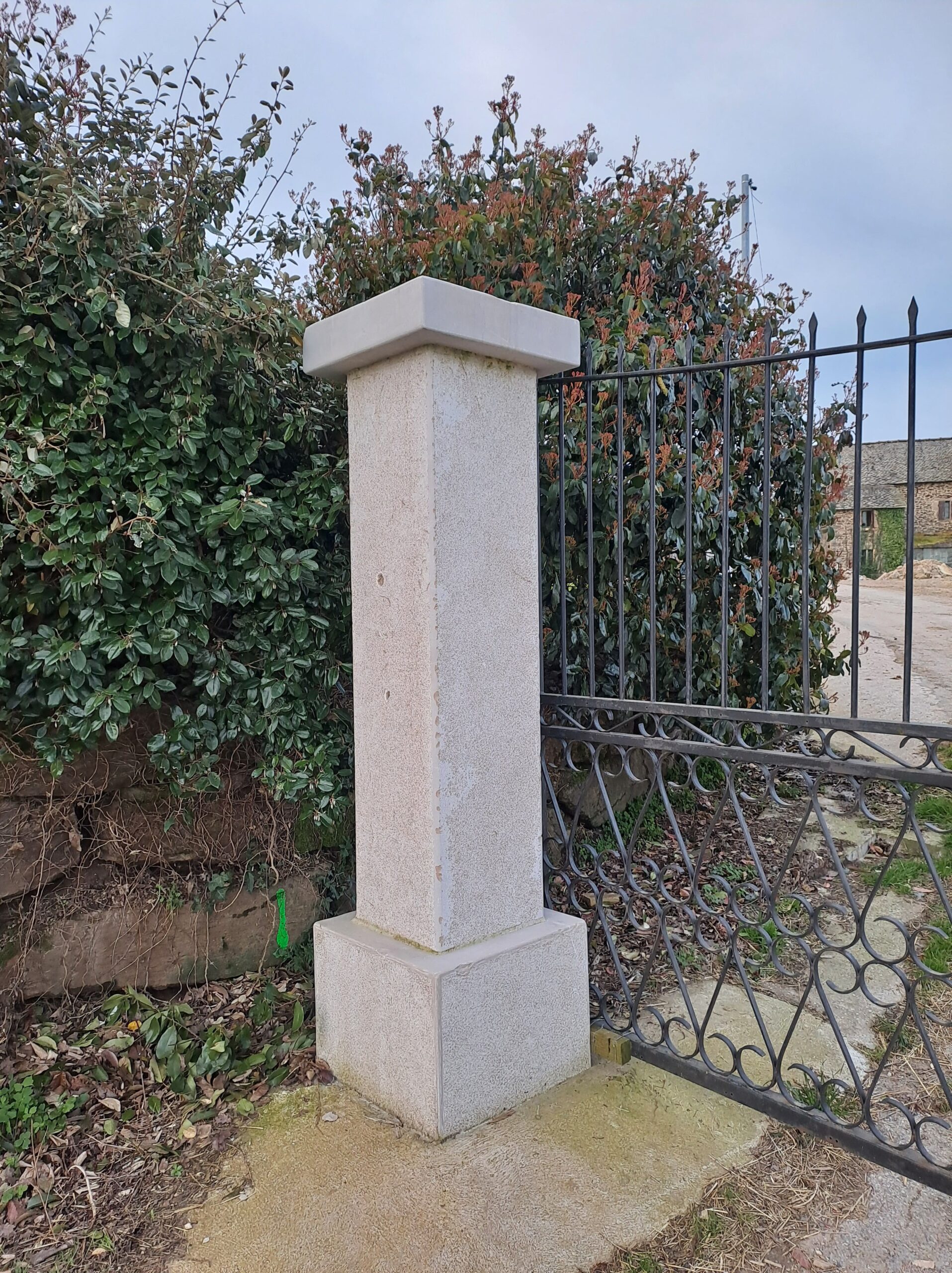 Pilier de portail en pierre et grille métallique noire par mobilier-design-pierre-aveyron en Aveyron