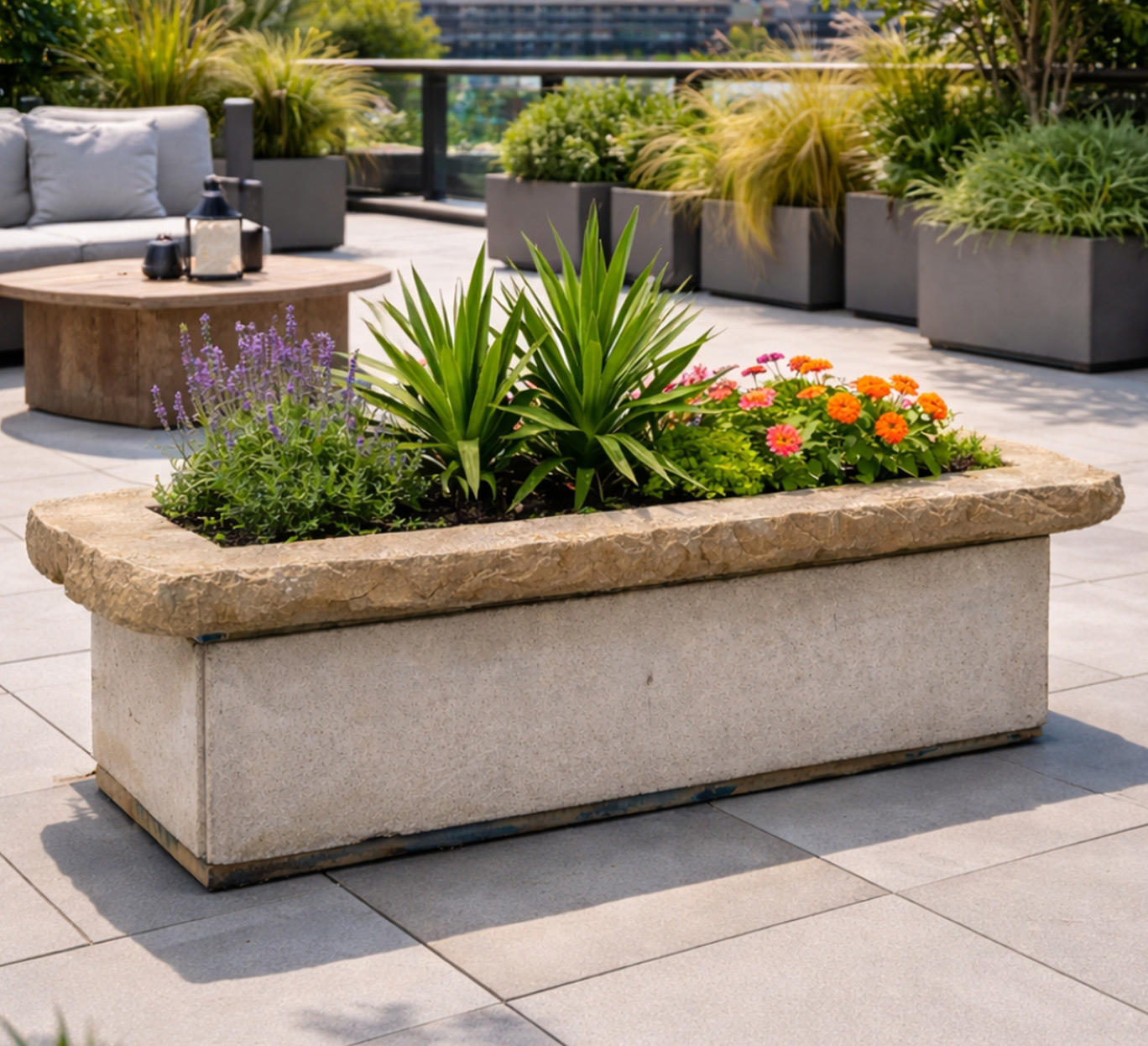 Bac en pierre avec plantes colorées sur terrasse moderne mobilier-design-pierre-aveyron en Aveyron